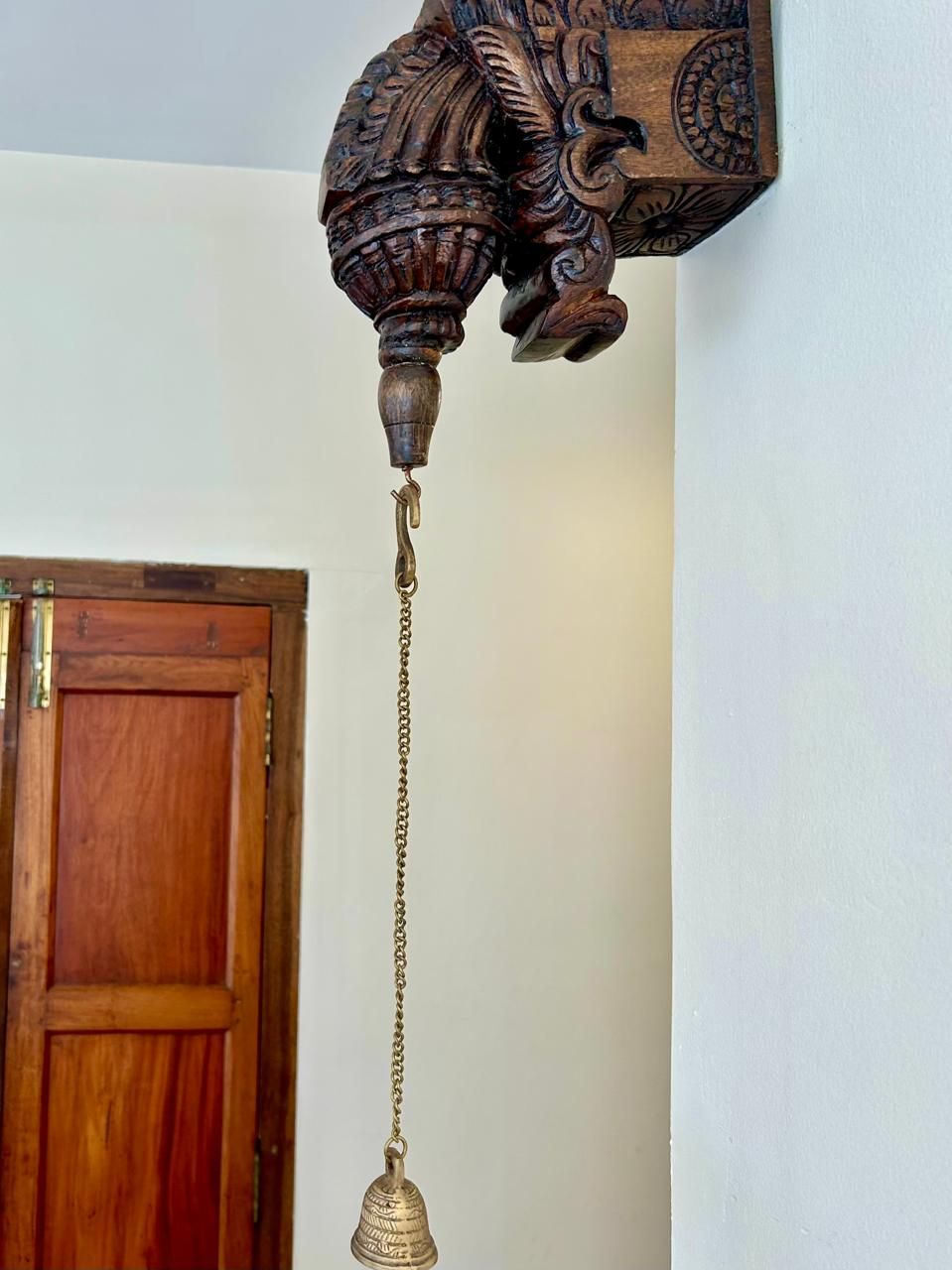 A wooden door with a brass doorknob and a brass handle.