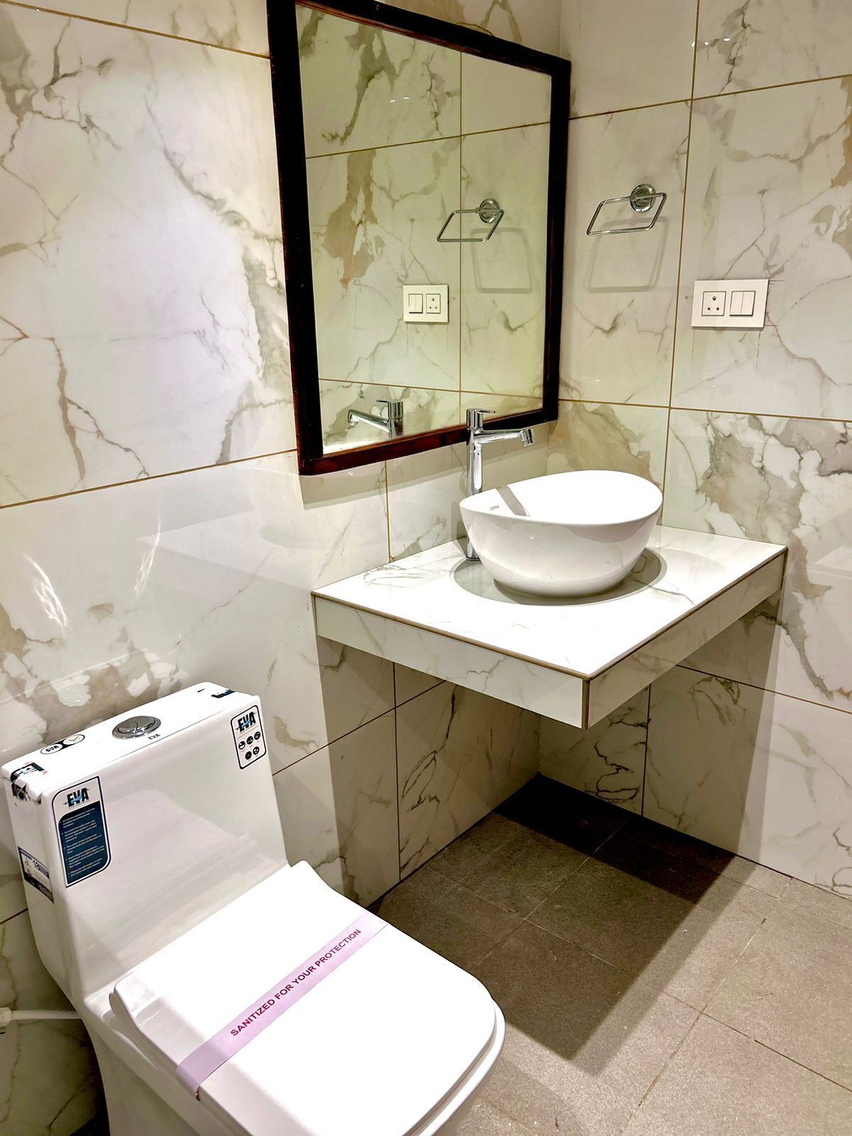Ein Badezimmer mit Toilette, Waschbecken und einem Spiegel darüber.