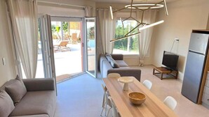 Una sala de estar moderna con un sofá, una mesa de comedor y un televisor.