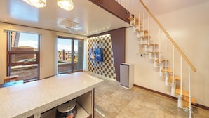 A modern kitchen with a granite countertop, a built-in oven, and a view of a deck through glass doors. - Geoje Piscina Pool Villa (Geoje)