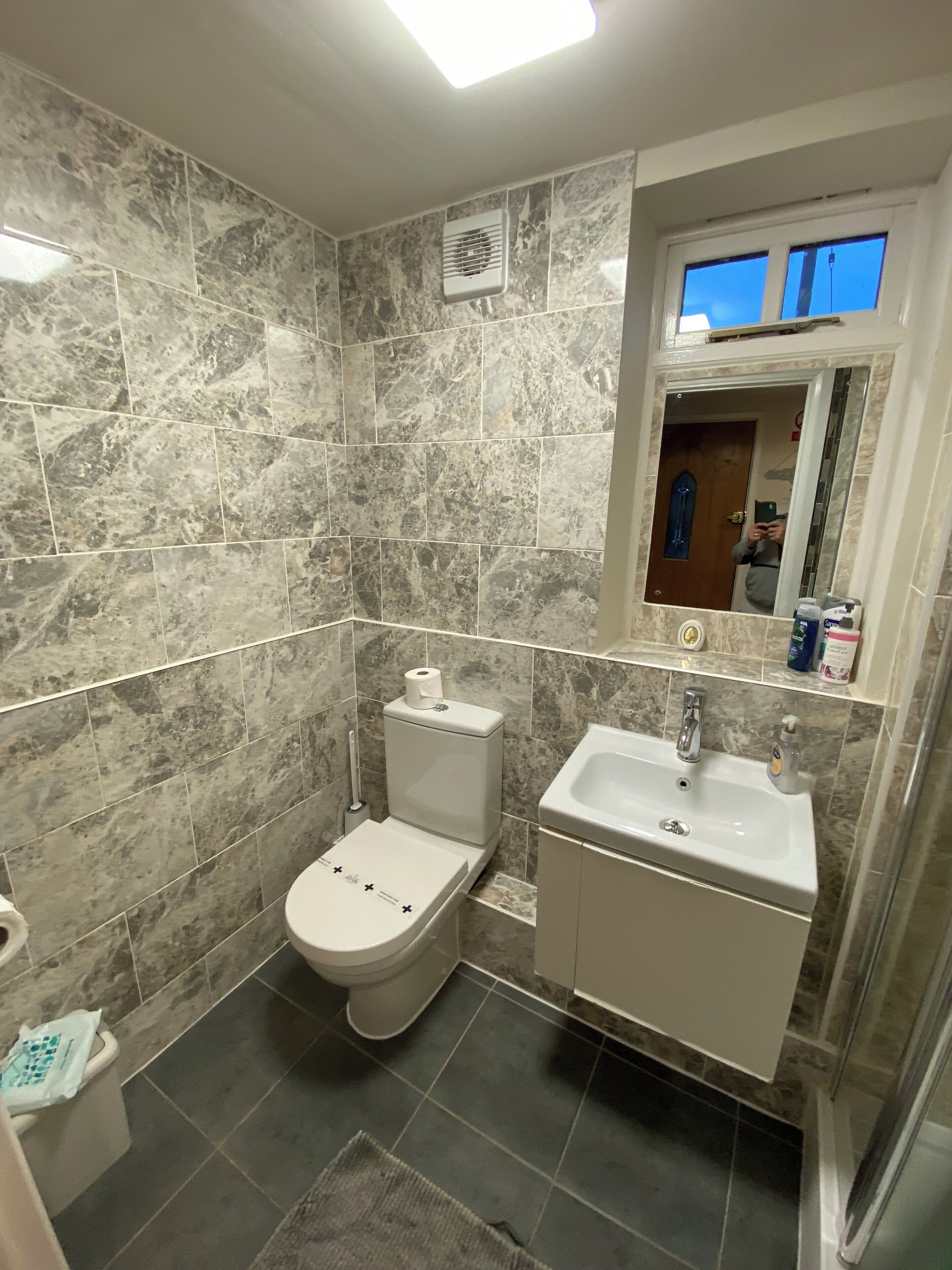 Ein Badezimmer mit Toilette, Waschbecken und Spiegel.