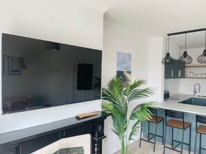 Eine moderne Küche mit weißer Arbeitsplatte, schwarzen Schränken und einem großen Fenster.