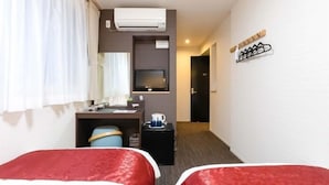 A hotel room with two beds, a desk with a computer, a TV, and an air conditioning unit. - KYOTO INN MIO (Kyoto)