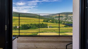 A balcony with a view of a rural landscape, including fields and distant buildings. - Cosy apartment for 6 guests with WIFI, TV and balcony (Klášterec Nad Ohrí)