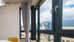 A room with a large window, a table, and a chair.