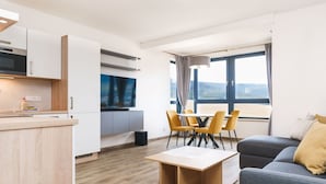 A modern apartment with a kitchen, dining area, and living room.