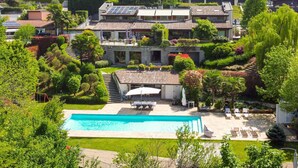 Ein großzügiges Haus mit Swimmingpool, umgeben von üppiger Vegetation und einem gepflegten Garten.
