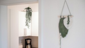 A kitchen with a coffee maker and a hanging plant. - Cozy barrier-free apartment in central Vegesack/2-4 pers. (Bremen)