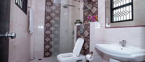 A bathroom with a toilet, sink, and shower.
