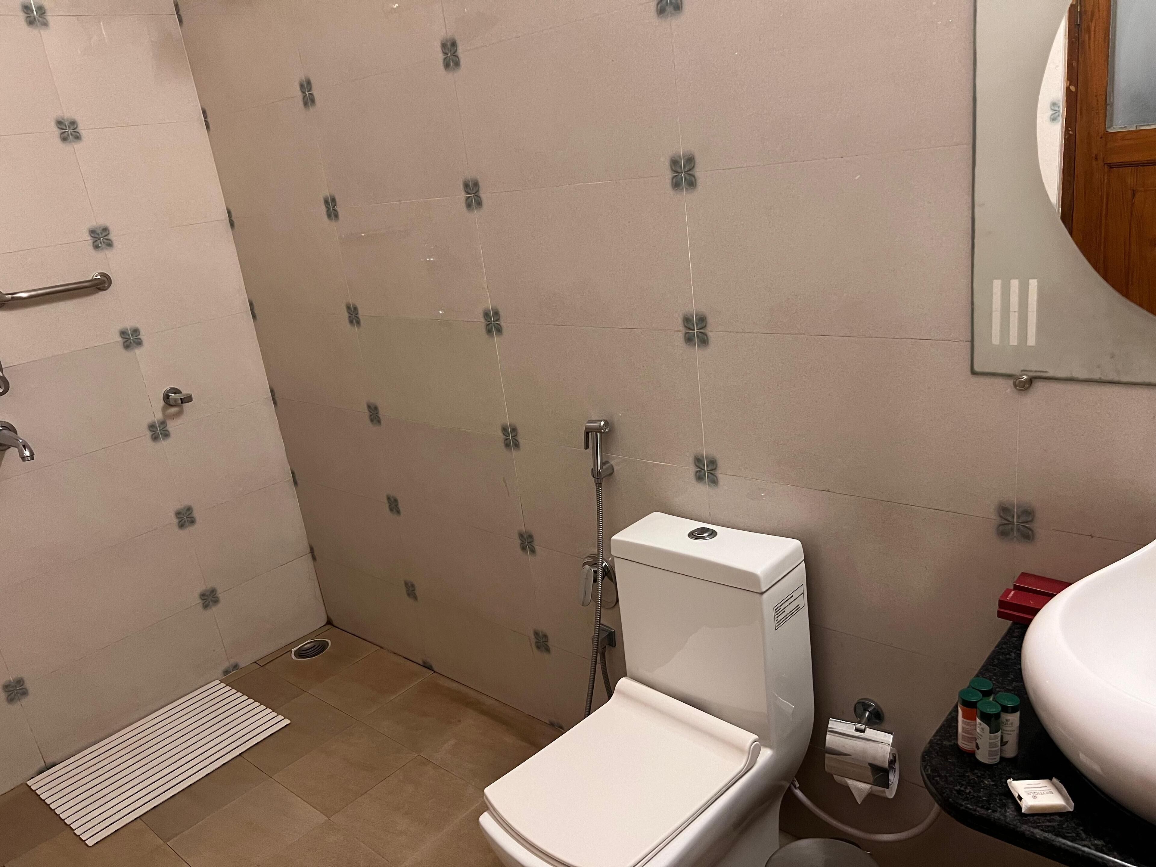 A bathroom with a toilet, shower, and sink.