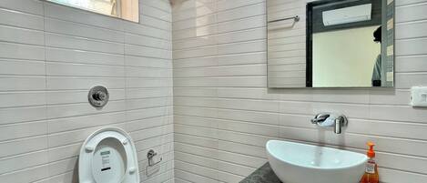 Un bagno con il water, un lavandino e uno specchio.