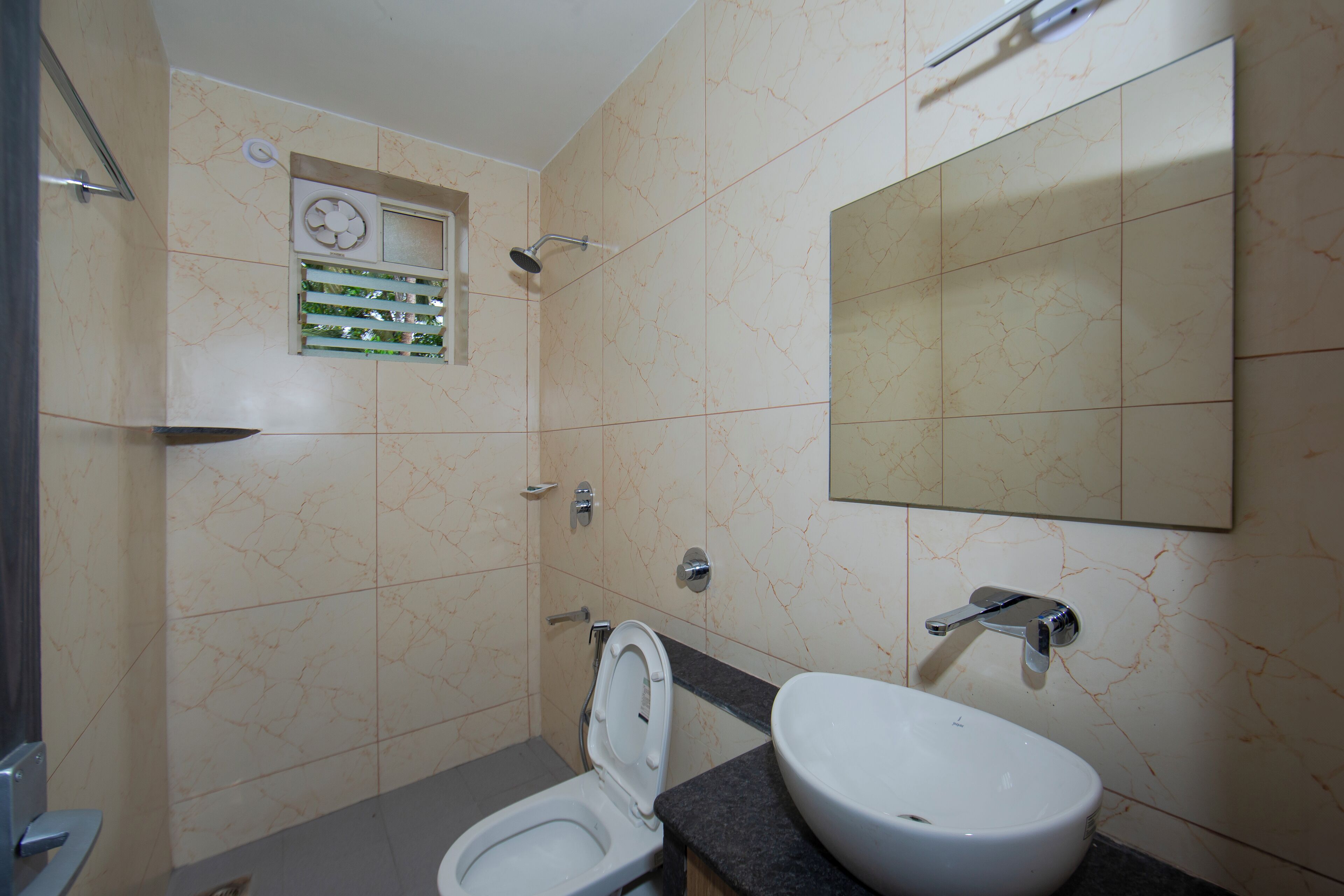 Egy fürdőszoba, amelyben WC, mosdókagyló és tükör található.