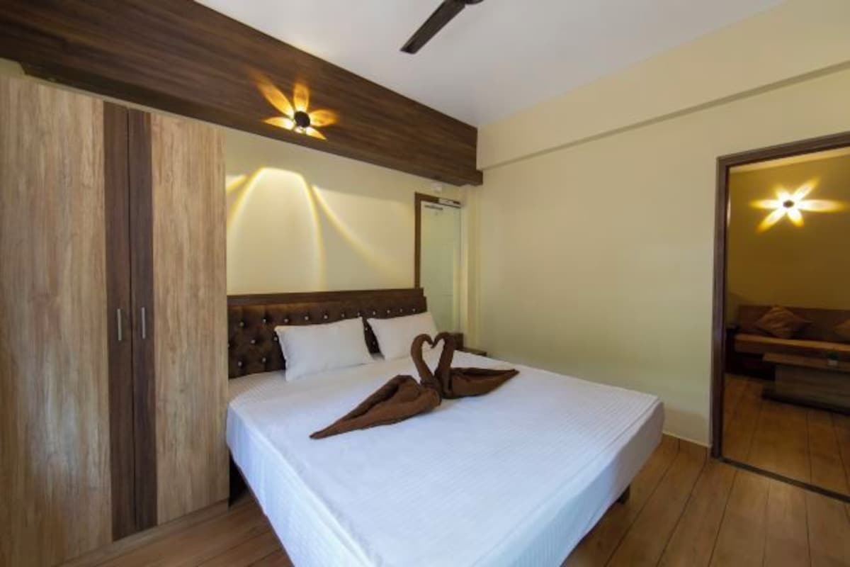 Un dormitorio con cama, armario de madera y espejo.