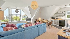A modern loft apartment with a large living area, dining space, and kitchen.