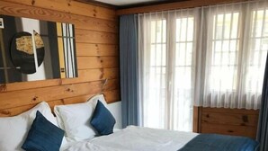 Un letto con una testiera in legno, biancheria da letto bianca e dettagli blu.
