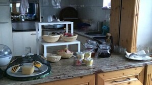 Una cucina con mobili in legno, un piano di lavoro in granito e diversi oggetti da cucina.