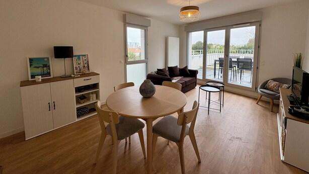 Ein modernes Wohnzimmer mit Essbereich, großen Fenstern und Blick ins Freie.