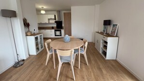 Eine moderne Küche mit weißen Schränken, einem Holztisch und Stühlen.