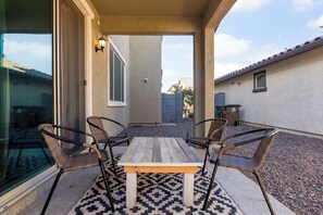 Relax on the patio with a clear view of the surrounding neighborhood, featuring a table and four chairs.