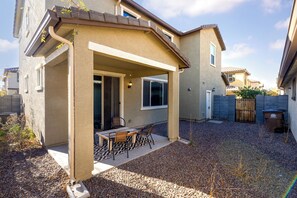 Enjoy a patio with a table and chairs, surrounded by a fenced backyard with a gravel ground cover.