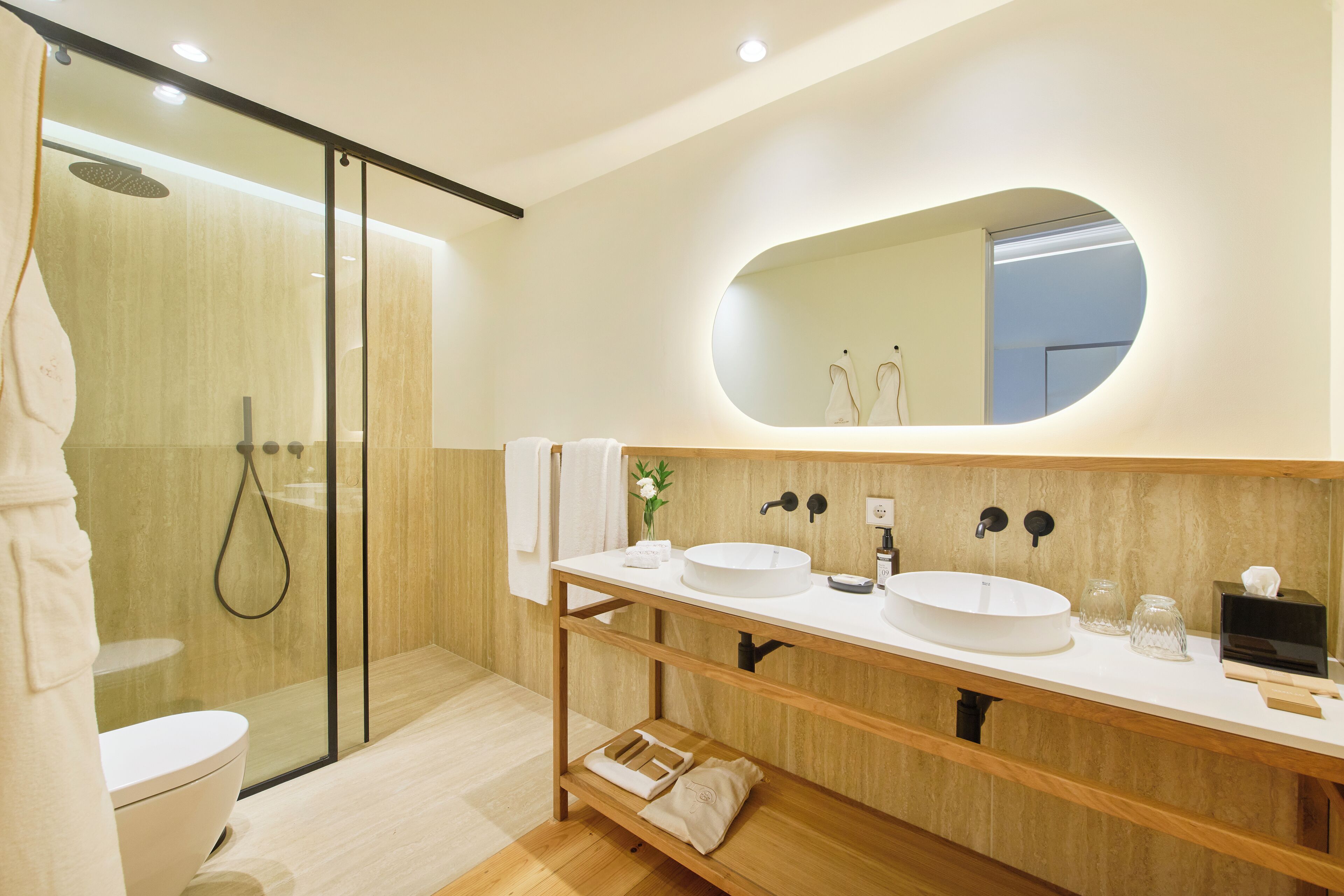 A modern bathroom with a glass-enclosed shower, a white sink, and a large mirror.