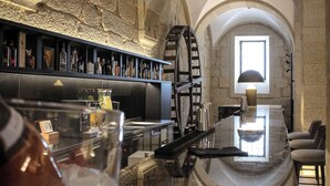 A bar area with a marble countertop, a large wine barrel, and a stone wall. - MS Collection Arouca Mosteiro de Arouca (Arouca)