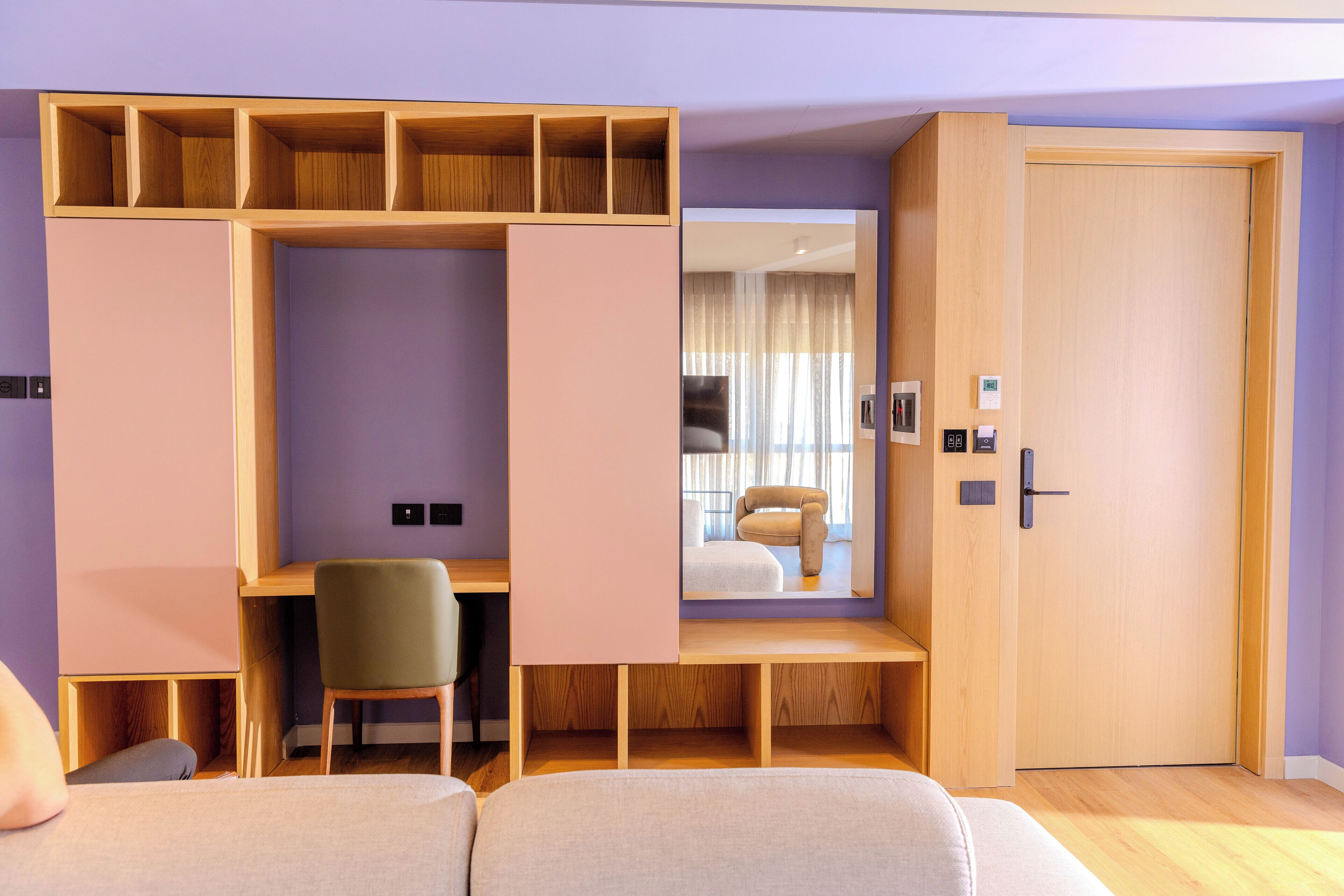 A room with a bed, a desk, a chair, and a wardrobe.