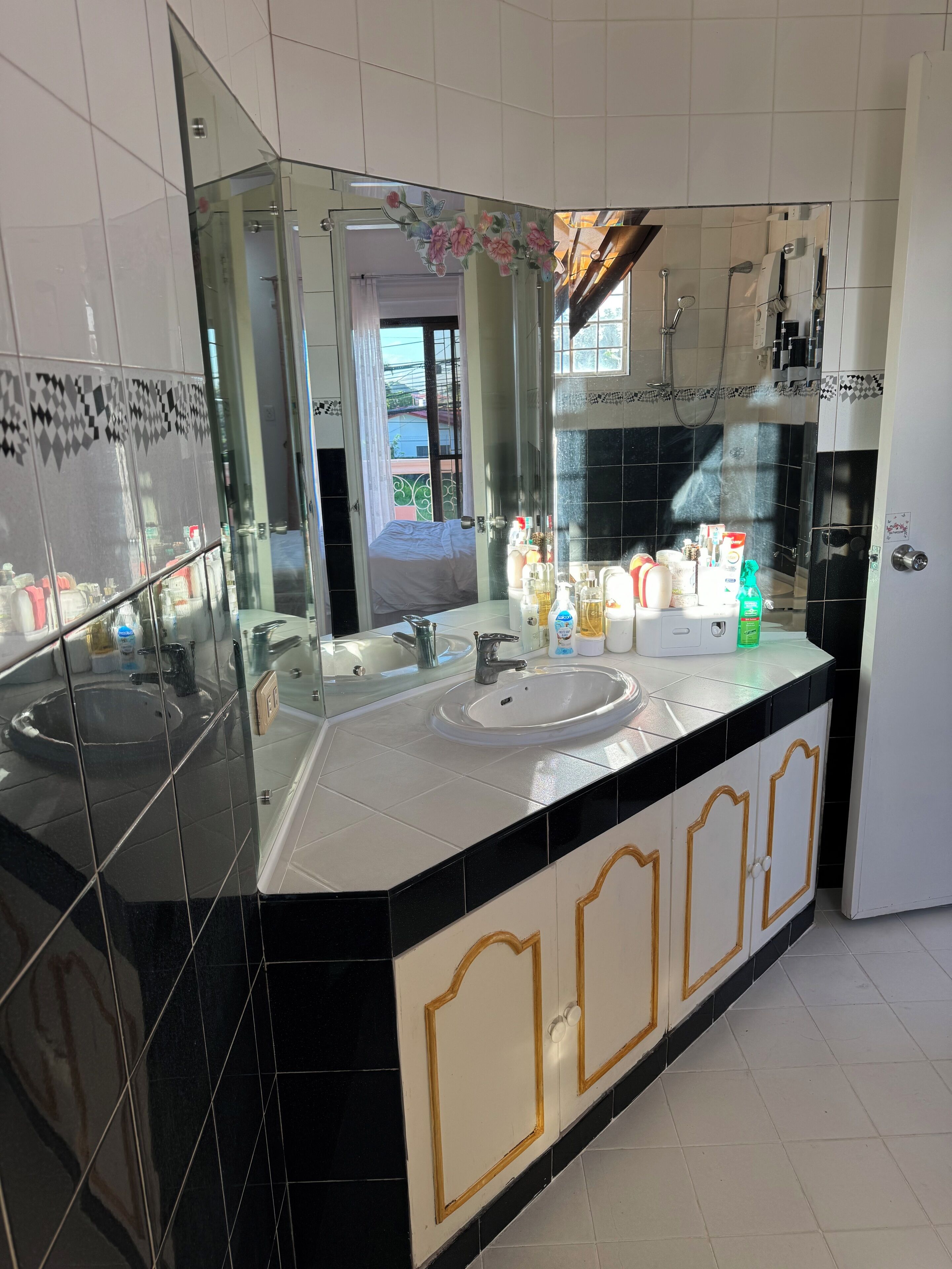 Une salle de bain moderne avec deux lavabos, un grand miroir et un espace douche.