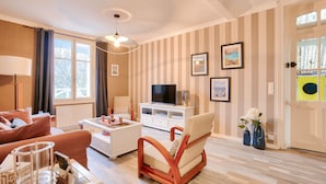 Un salon comprenant un canapé, une table basse, un meuble pour la télévision et des objets de décoration.