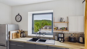 A modern kitchen with a built-in window, stainless steel appliances, and a tiled backsplash. - In the heart of the village, house for 8 with pool (Coly)
