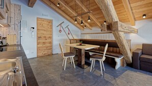 A rustic interior with exposed wooden beams, a wooden bench, and a dining table with chairs. - Vacation apartment "Tischlerhof Stadl" (St.Jakob/Ahrntal)