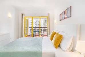 A hotel room with a bed, a nightstand, a window with curtains, and a view of the outside balcony. - Praia da Rocha/906/CPRocha/Near the Beach/by IG (Portimão)