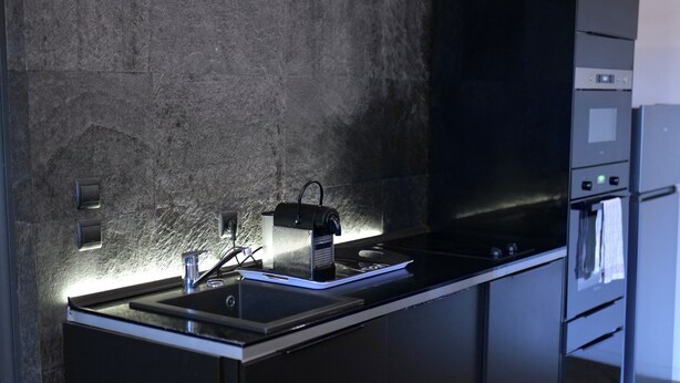 A modern kitchen with a granite countertop, stainless steel appliances, and a built-in oven. - Les Cinq Lys (Carcassonne)