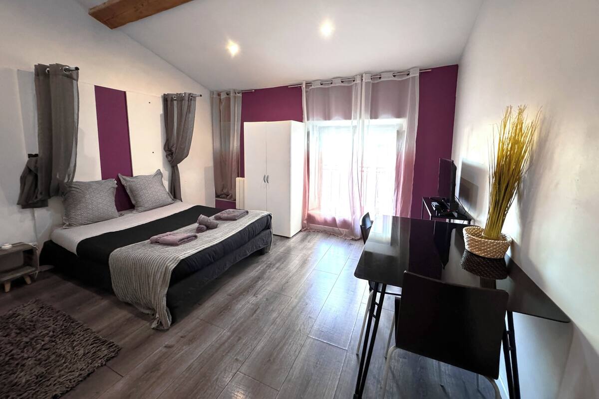 Un dormitorio moderno con cama, escritorio y armario.