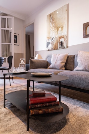 Ein modernes Wohnzimmer mit Sofa, Couchtisch und Bücherregal.