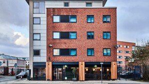 Un immeuble à plusieurs étages, doté d’une façade en briques, de grandes fenêtres et d’un toit plat.