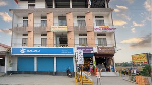 Un edificio de varios pisos con letreros que dicen 'Royal Residency' y 'Bajaj Highway Bajaj'.