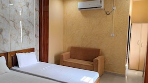 Una habitación de hotel con una cama, una silla y un armario.