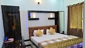 Una camera d'albergo con un letto grande, un comodino, uno specchio e una finestra con tende.