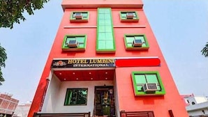 Un edificio alto e rosso con un cartello che recita 'HOTEL LUMBINI INTERNATIONAL'.