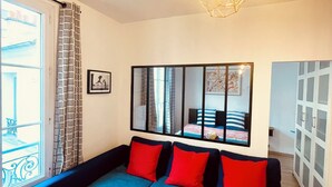 A modern living room with a sectional sofa, a coffee table, and a large mirror reflecting the room. - Quiet, bright apartment in the heart of Paris 13 (Paris)