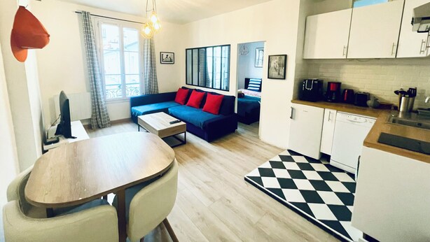 A compact living space with a dining area, a kitchenette, and a bedroom. - Quiet, bright apartment in the heart of Paris 13 (Paris)