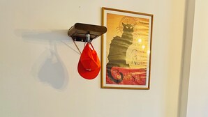 A small dining area with a round wooden table and two white chairs. A red bag hangs on a hook above the table. - Quiet, bright apartment in the heart of Paris 13 (Paris)