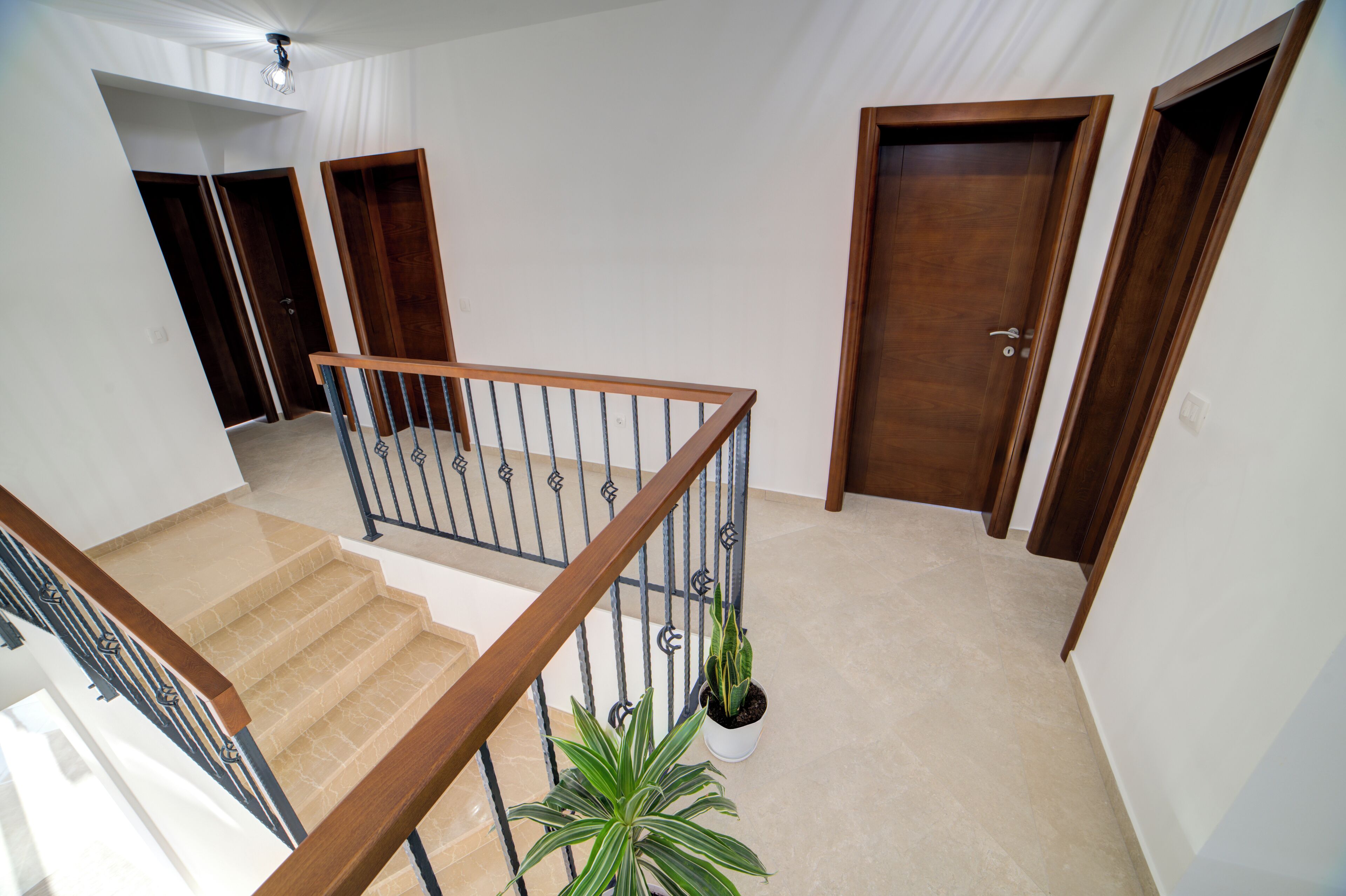 A staircase with wooden railings and a potted plant.