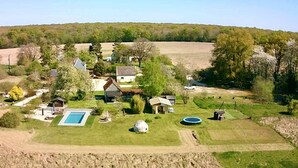 A rural property with a swimming pool, a large house, and several smaller structures.