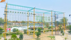 A playground with various climbing structures and a river in the background. - eco park (Huzur)