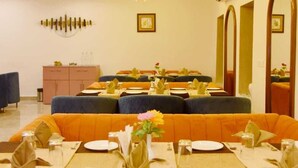 A dining area with round tables set for four, blue upholstered booths, and a ceiling with recessed lighting. - eco park (Huzur)