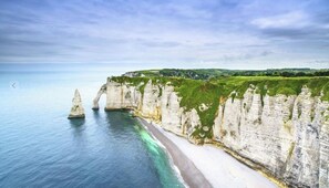 A coastal landscape with white cliffs, a beach, and a clear sky. - Gîte de la Tannerye near ETRETAT (Le Tilleul)