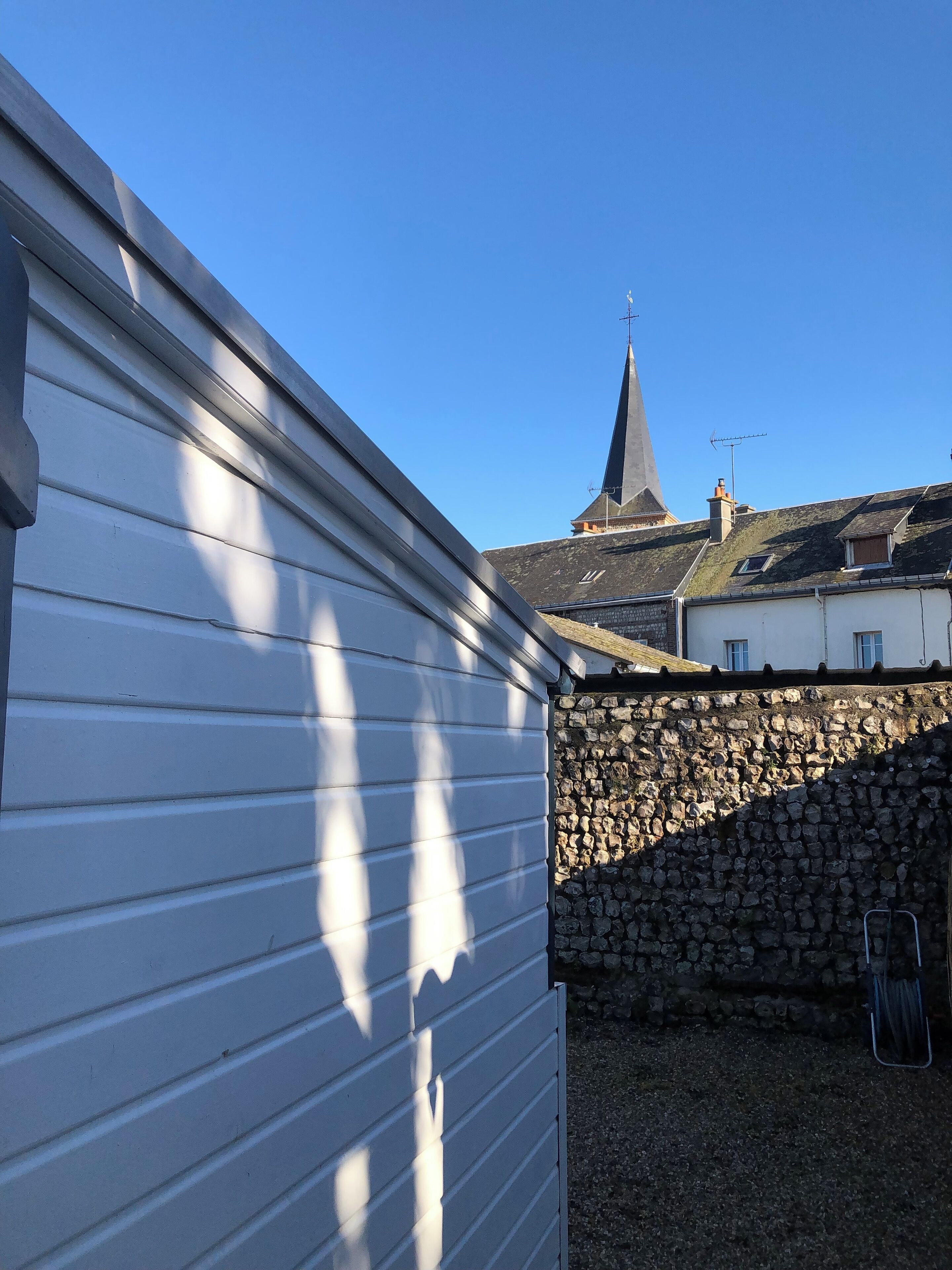 A building with a stone wall and a metal roof.