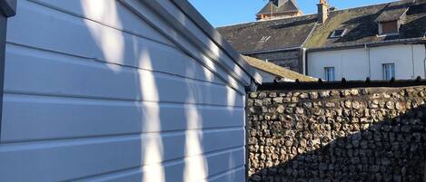 A building with a stone wall and a metal roof.